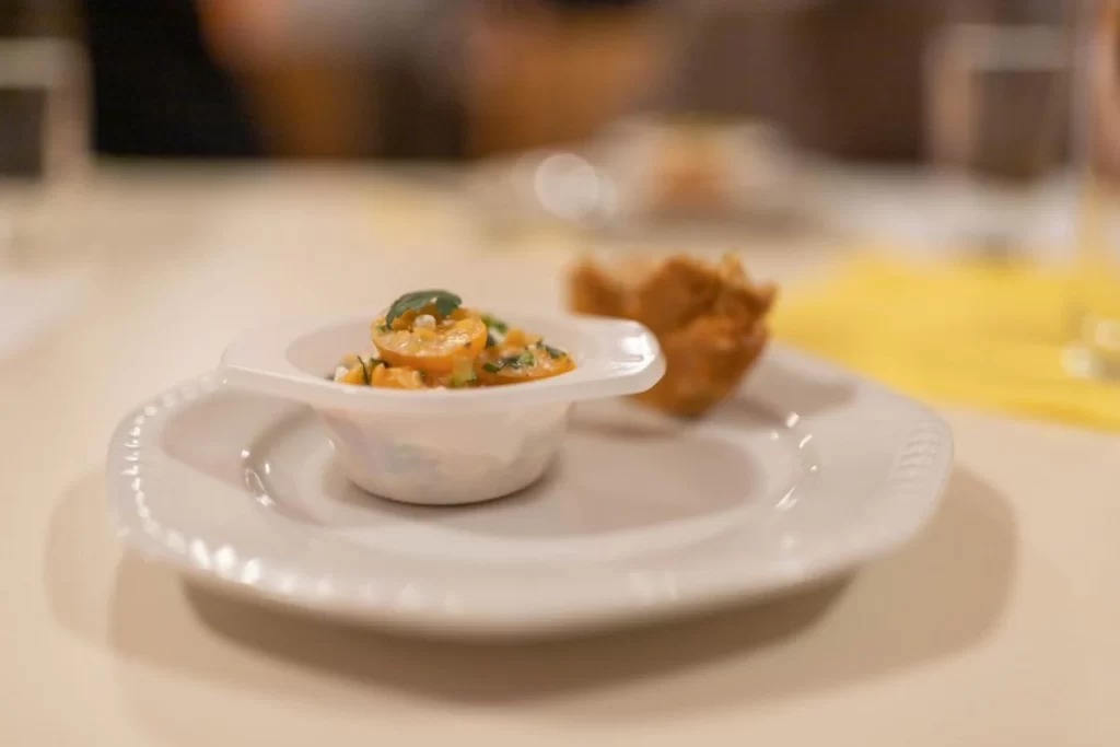 Prato com porção de comida que inclui camarão e temperos, representando o menu degustação.