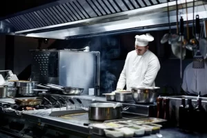 Chef trabalhando em cozinha industrial.