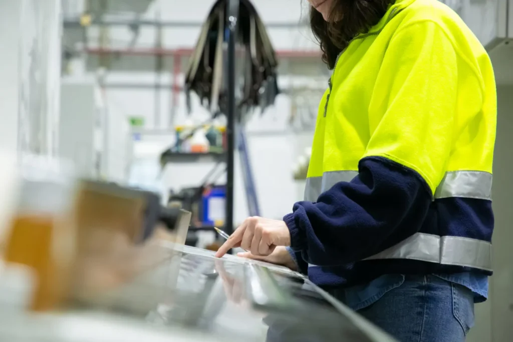 Gerador a gás GLP: vale a pena investir em 2026? Técnico usando luvas e colete de segurança realiza testes e manutenção em equipamentos em ambiente industrial, com destaque para o trabalhador e a preparação do gerador a gás GLP.
