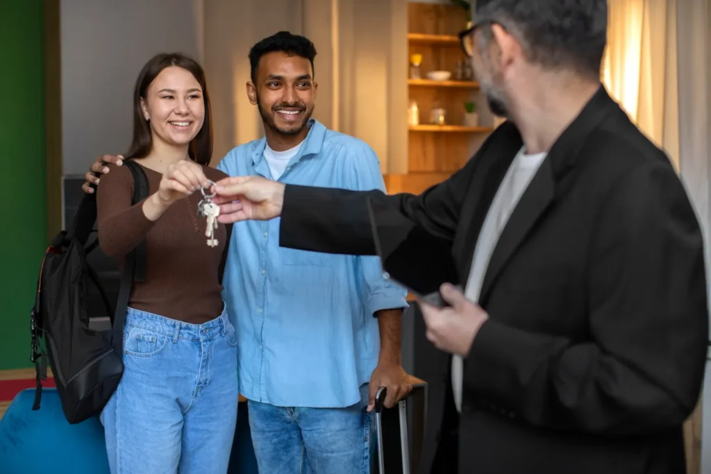 Como o gás GLP encanado impulsiona a valorização de imóvel valorização de imóvel: Corretor imobiliário entrega as chaves para um casal que acabou de comprar um apartamento, em ambiente interno, com gesto de início de moradia e negociação imobiliária.